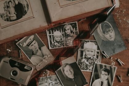 Stare rodzinne fotografie i aparat na drewnianym stole