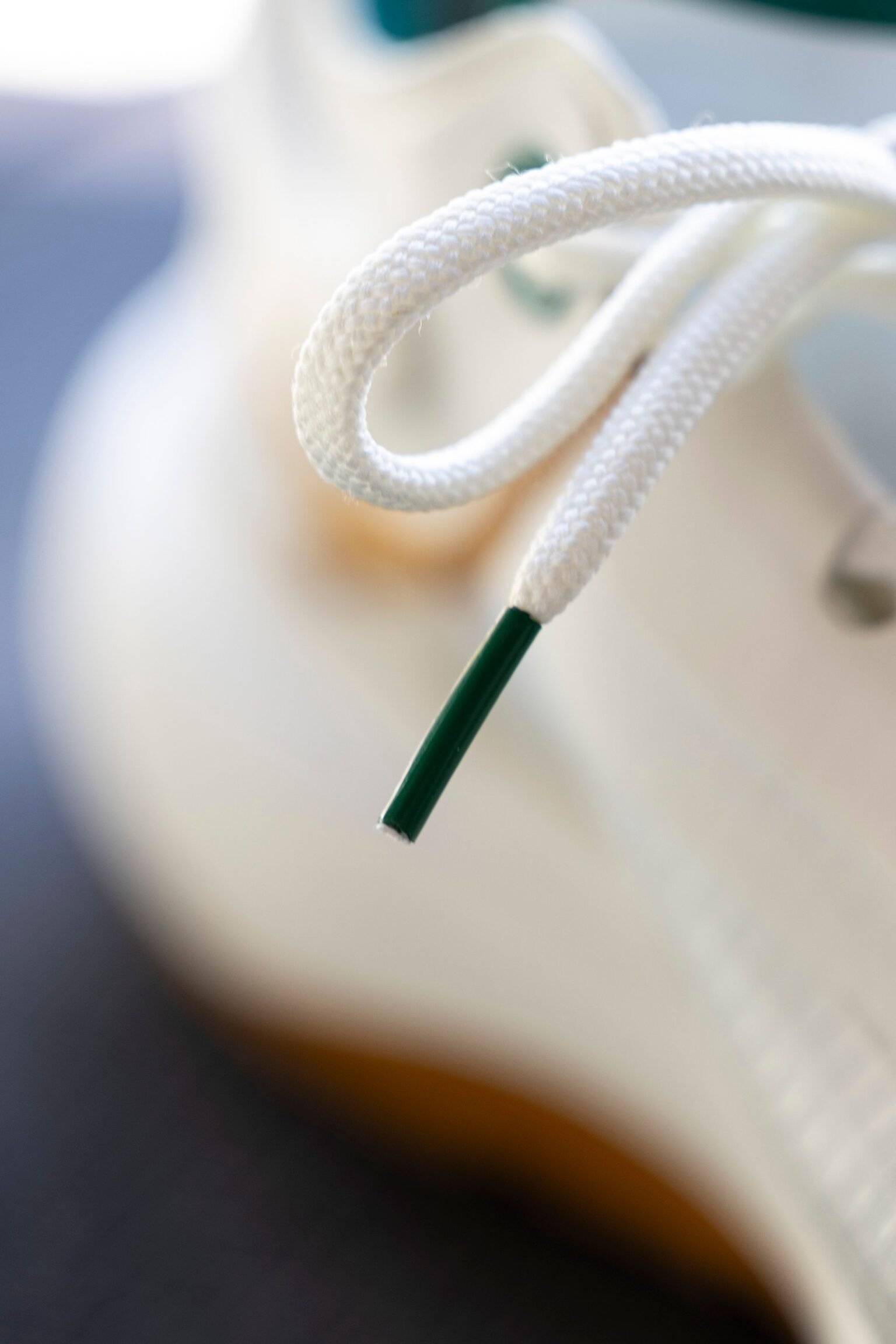 zbliżenie na ochronną plastikową końcówkę sznurowadła jako wizualna metafora telomerów chroniących końce chromosomów