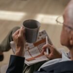 trening pamięci, starszy mężczyzna rozwiązuje krzyżówkę i trzymający kubek kawy jako trening pamięci i mózgu